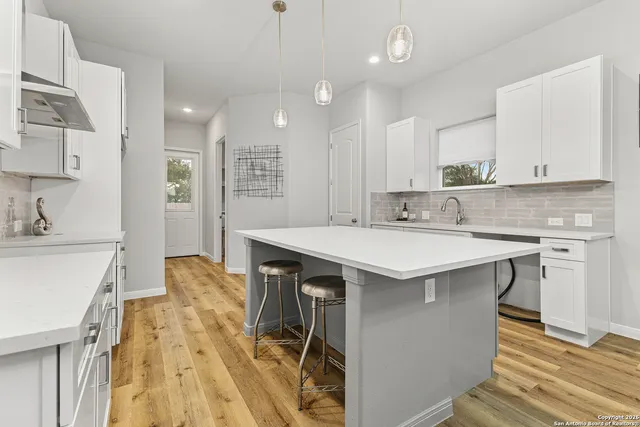 a kitchen with a sink appliances and cabinets