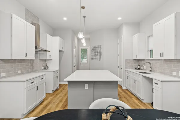 a kitchen with kitchen island a sink stainless steel appliances and cabinets
