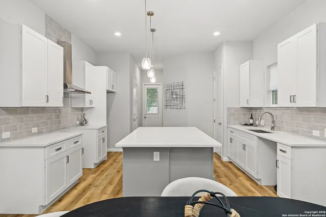 a kitchen with kitchen island a sink stainless steel appliances and cabinets