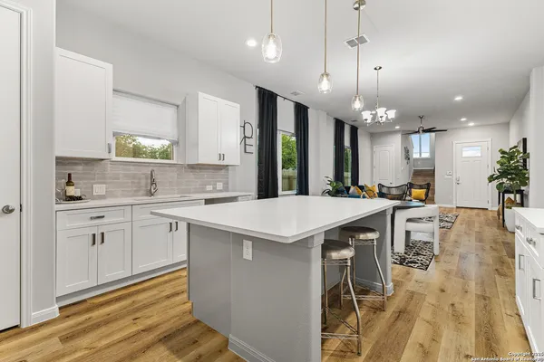 a large kitchen with kitchen island a sink table and chairs