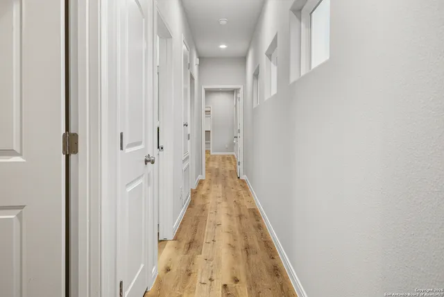 a view of a hallway with wooden floor and staircase