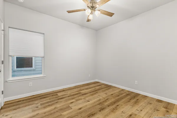 a view of empty room with wooden floor