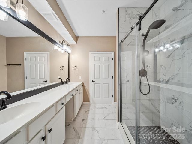 a spacious bathroom with a glass shower door and a sink