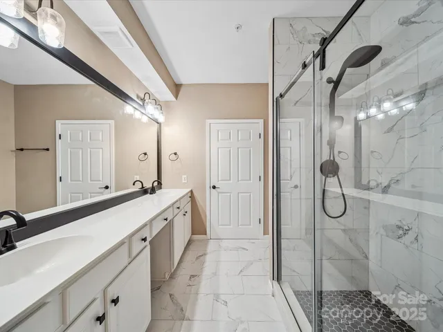 a spacious bathroom with a glass shower door and a sink