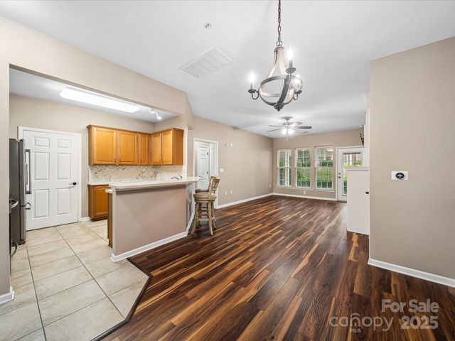 a view of a kitchen with wooden floor and windows