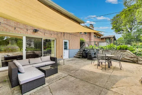 a view of a patio with couches and table and chairs and potted plants
