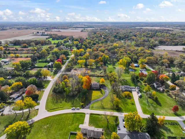 an aerial view of residential houses with outdoor space and trees