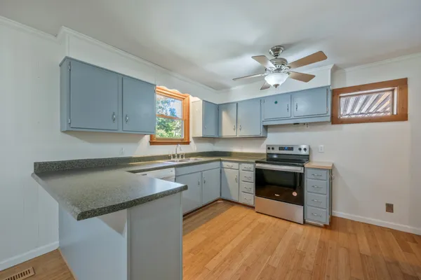 a kitchen with stainless steel appliances granite countertop a stove a sink and a refrigerator