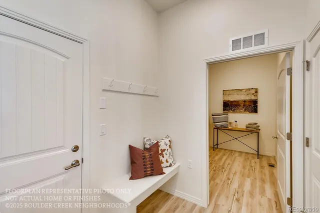 a view of a hallway with wooden floor and a bathroom