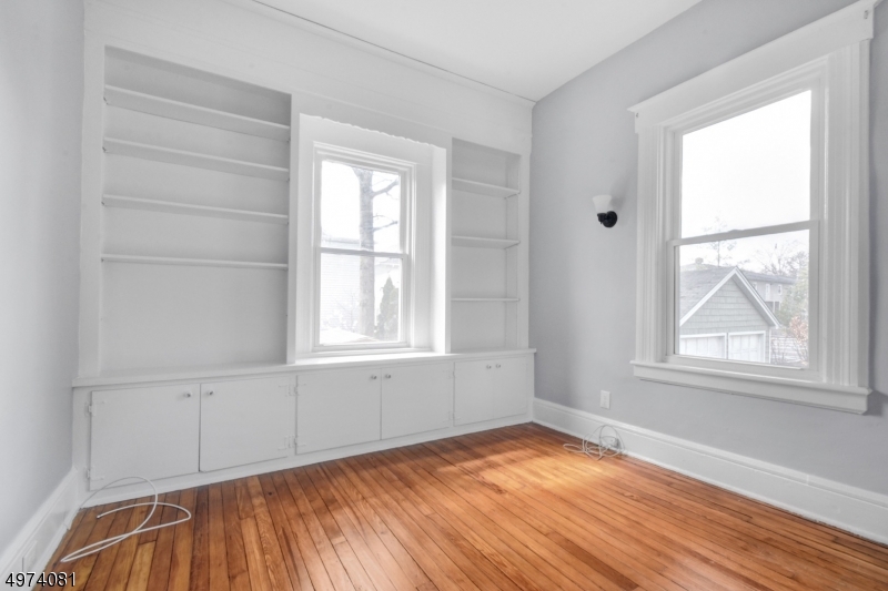 558 Summit Avenue, Unit 1 Westfield, NJ 07090 - Photo 4 of 13 an empty room with wooden floor and windows