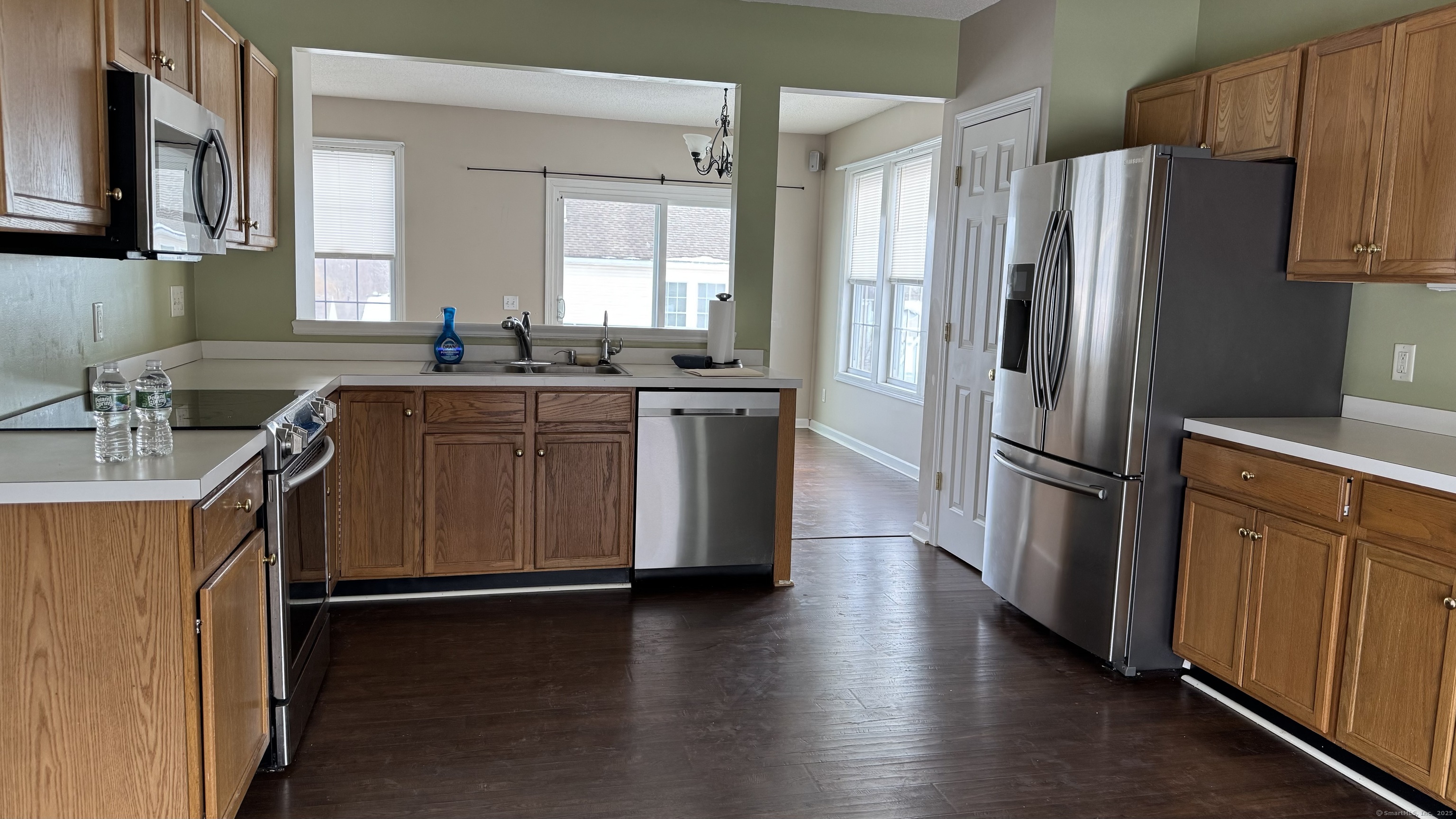 40 Mountain Laurel Way, Unit 40 Suffield, CT 06078 - Photo 2 of 16 a kitchen with stainless steel appliances a refrigerator a sink a stove a microwave and wooden floors