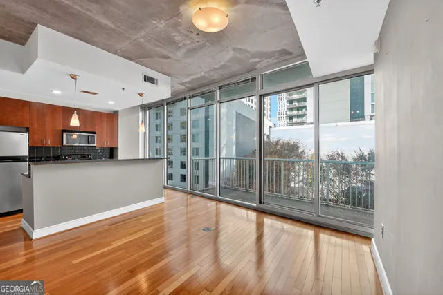 a view of a kitchen with stainless steel appliances wooden floor and a large window