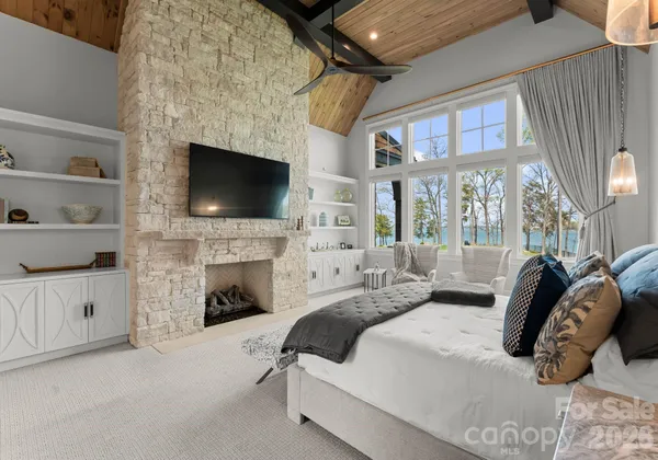 a bedroom with furniture a fireplace and a flat screen tv