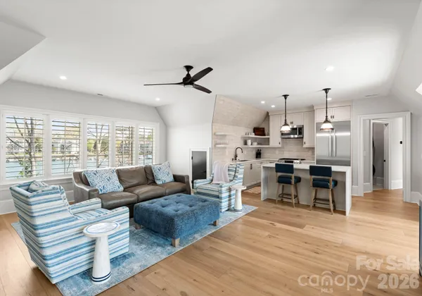 a living room with furniture kitchen view and a large window