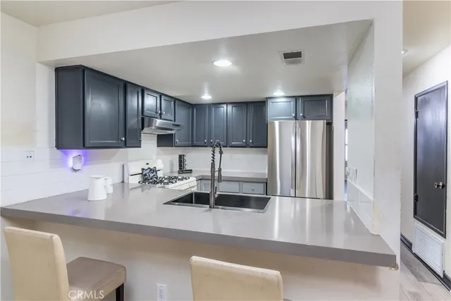 a kitchen with stainless steel appliances a sink stove and cabinets