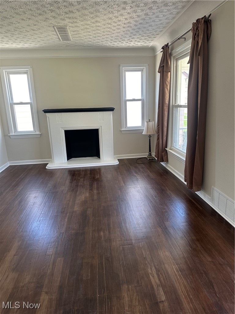 18230 Libby Road Maple Heights, OH 44137 - Photo 16 of 39 Unfurnished living room with baseboards, visible vents, wood finished floors, and a fireplace with raised hearth