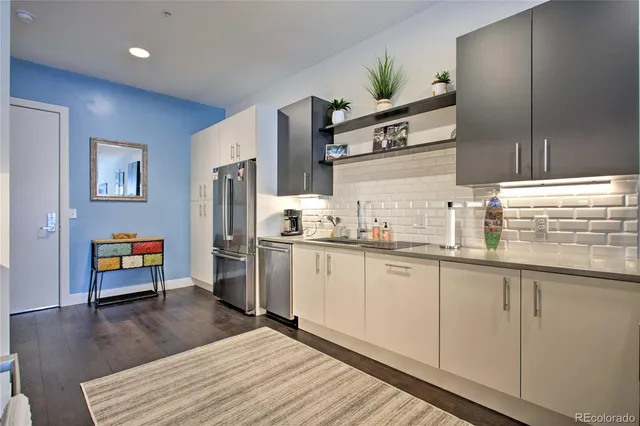 a kitchen with stainless steel appliances granite countertop a refrigerator a stove and a sink