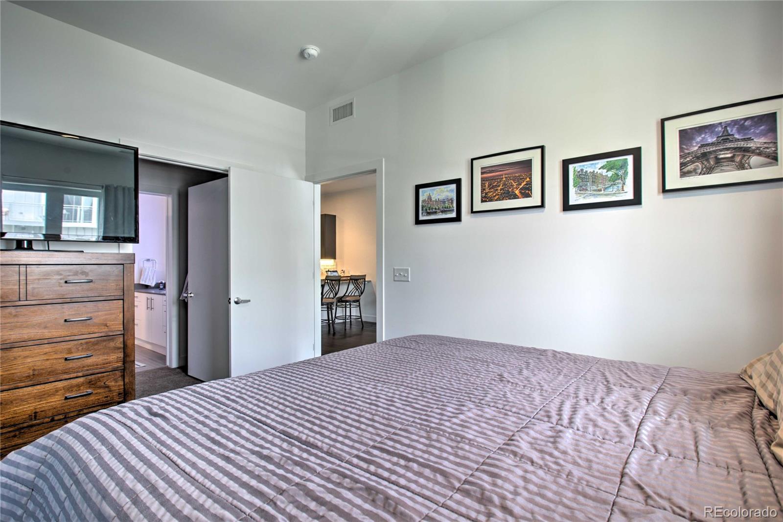 2550 Lawrence Street, Unit RB204 Denver, CO 80205 - Photo 18 of 36 a bedroom with a bed and a dresser