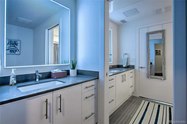 a bathroom with double sink and a mirror