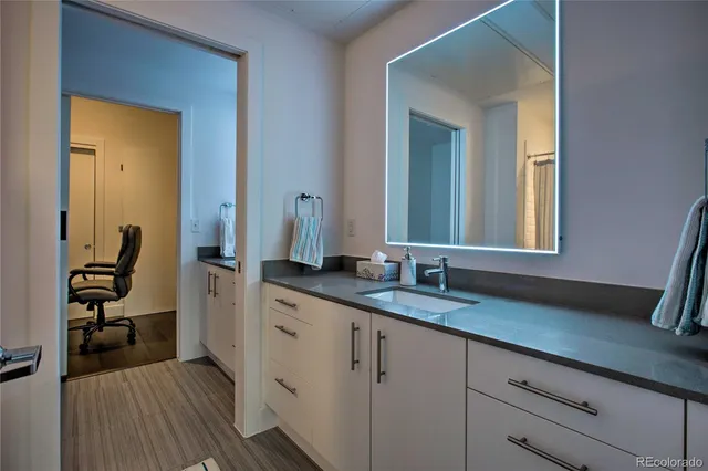 a en suite bathroom with a granite countertop sink and a mirror