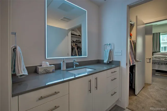 a bathroom with a granite countertop sink and a mirror