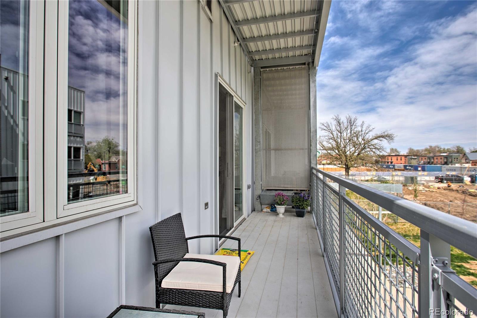 2550 Lawrence Street, Unit RB204 Denver, CO 80205 - Photo 27 of 36 a balcony with wooden floor and furniture