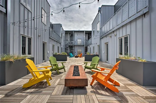 a view of a patio with couches table and chairs with wooden floor