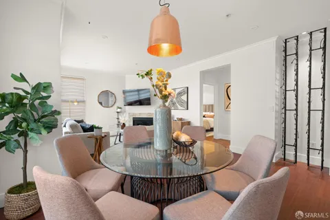 a dining room with furniture a chandelier and wooden floor