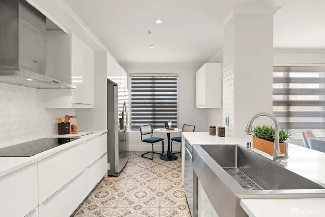 a large white kitchen with stainless steel appliances