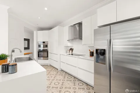 a large white kitchen with a table and chairs