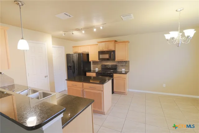 a kitchen with kitchen island granite countertop lots of counter top space and appliances