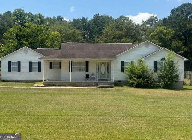 a view of house with garden and trees in the background