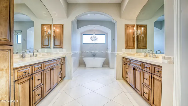 a bathroom with a double vanity sink a mirror and a bathtub
