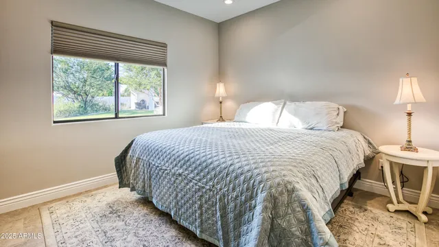 a large bed sitting in a bedroom next to a window