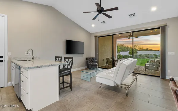 a living room with furniture a flat screen tv and a floor to ceiling window