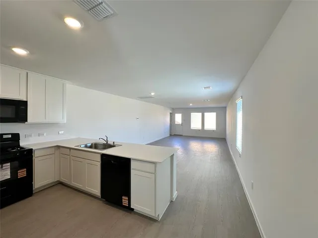 a view of a kitchen with a sink and dishwasher cabinets