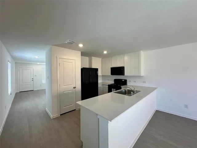 a kitchen with refrigerator and a sink