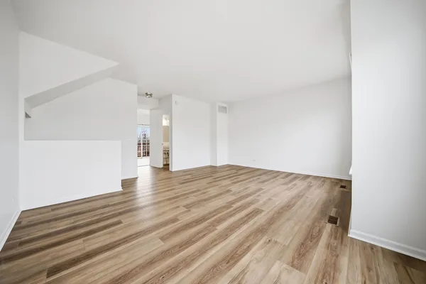 a view of empty room with wooden floor