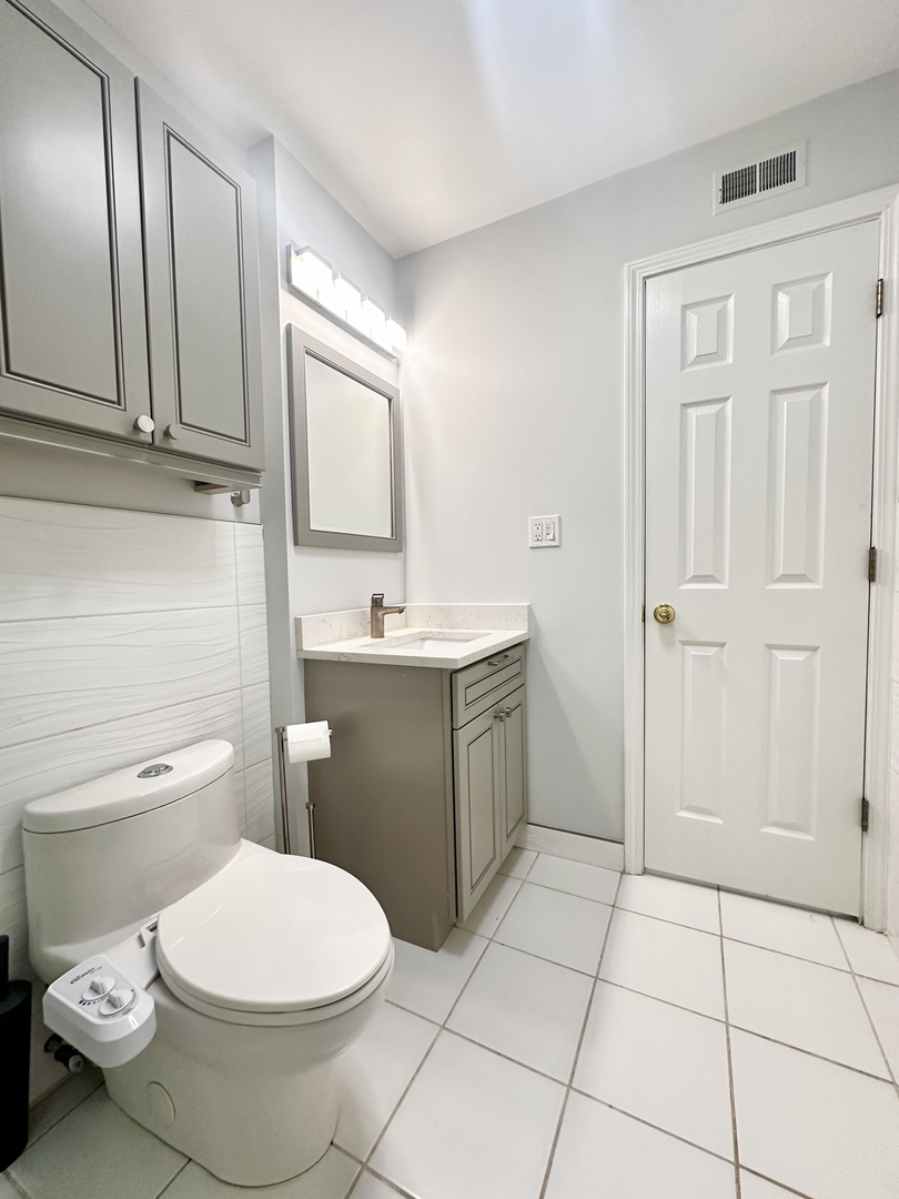 1603 North Windsor Drive, Unit 102 Arlington Heights, IL 60004 - Photo 10 of 18 a bathroom with a sink a toilet and mirror