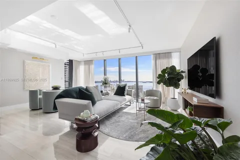 a living room with furniture a flat screen tv and a large window