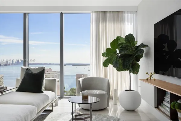 a living room with furniture potted plant and a large window
