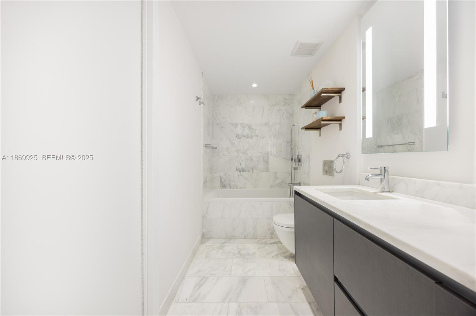 1451 Brickell Avenue, Unit 1901 Miami, FL 33131 - Photo 20 of 31 a bathroom with a sink a toilet and shower