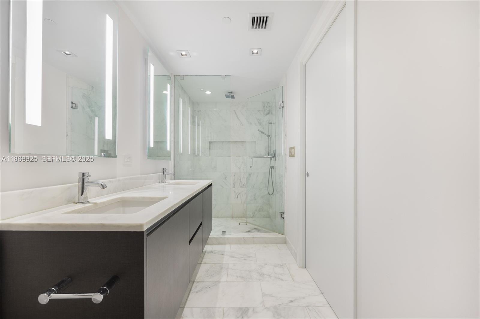 1451 Brickell Avenue, Unit 1901 Miami, FL 33131 - Photo 21 of 31 a bathroom with a sink and a mirror