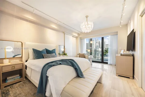 a spacious bedroom with a bed and a chandelier