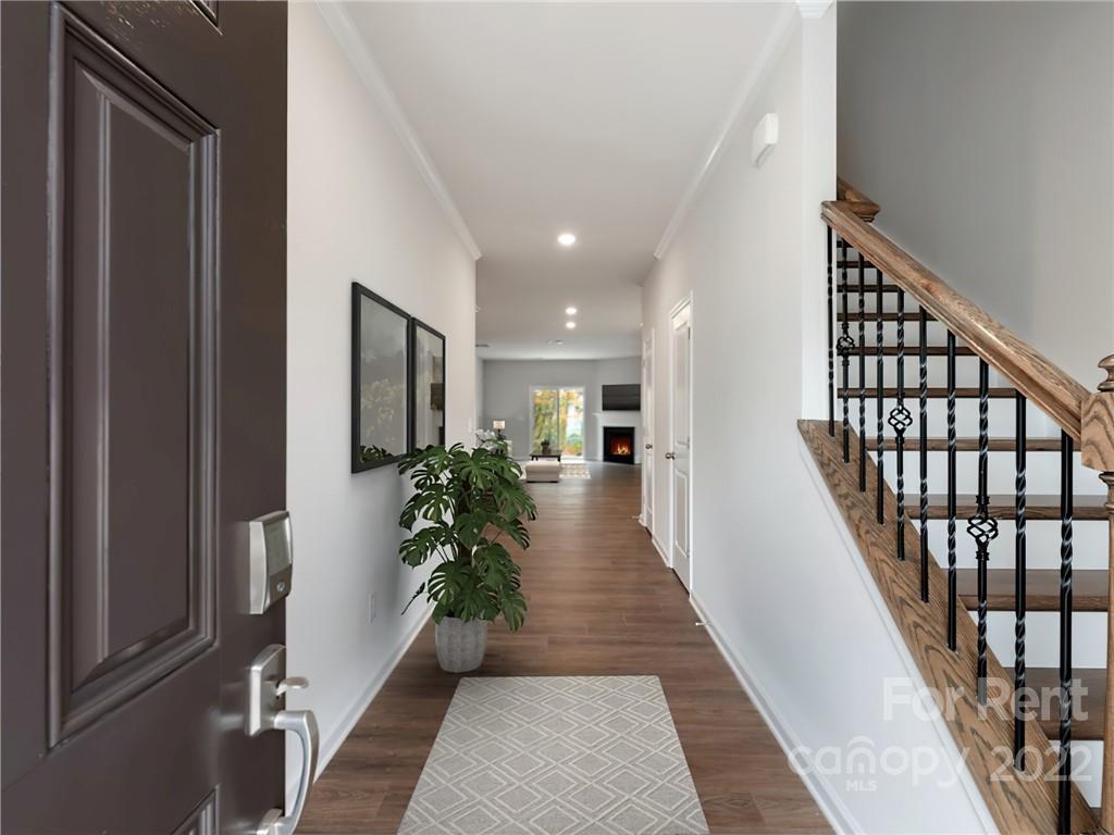 6531 Gopher Road Lancaster, SC 29720 - Photo 4 of 29 a hallway with wooden floor stairs and a potted plant