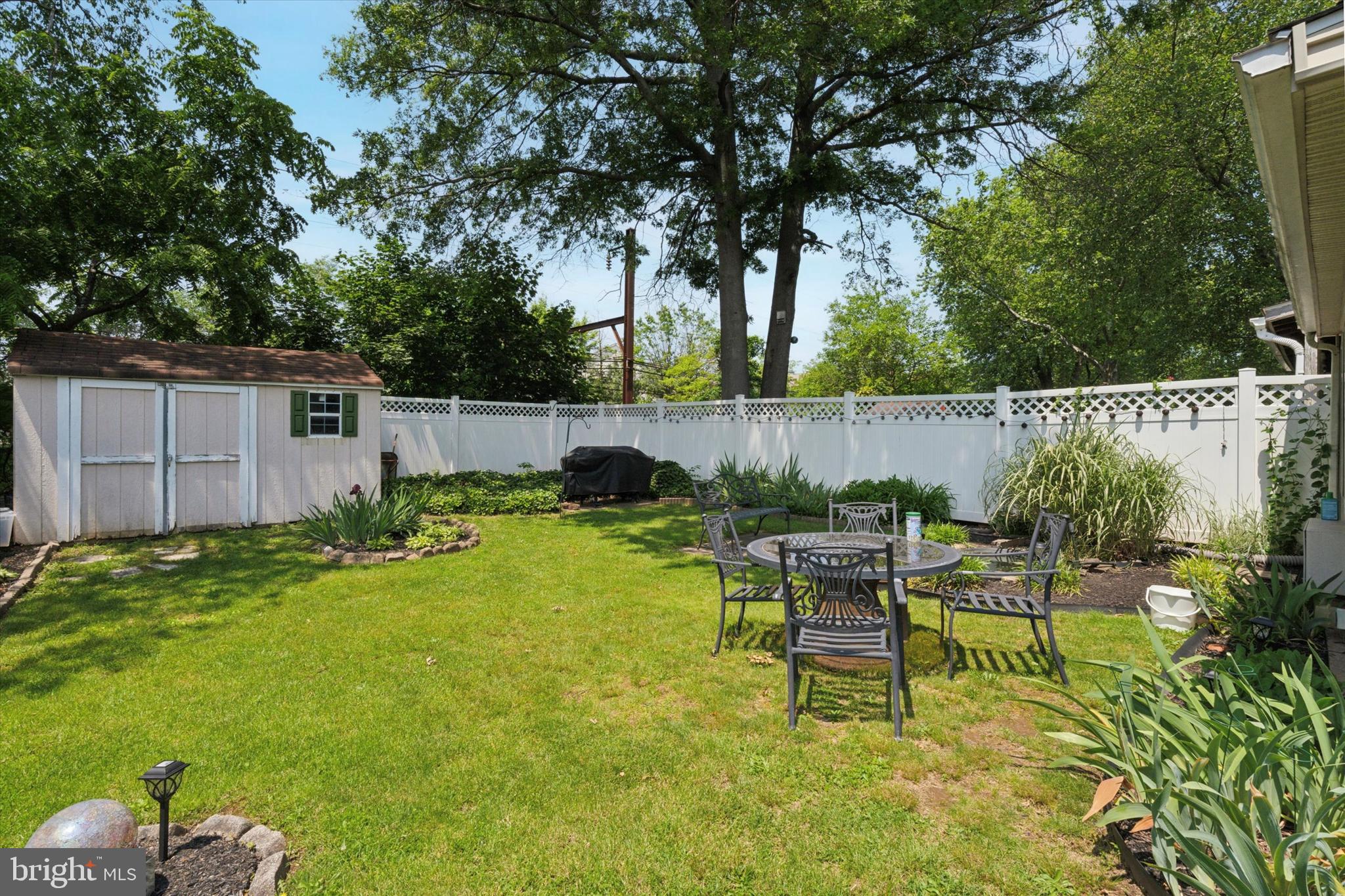 718 Cherry Street Lansdale, PA 19446 - Photo 21 of 23 a view of a backyard with table and chairs potted plants and large tree