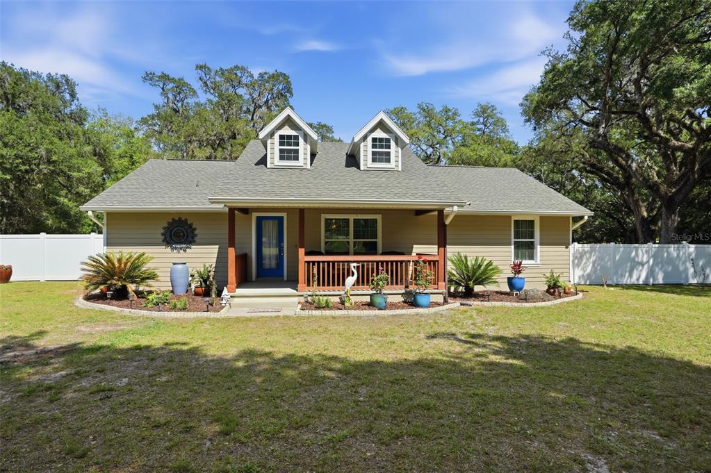 7037 County Road 625 Bushnell, FL 33513 - Photo 2 of 99 a front view of a house with swimming pool and porch with furniture