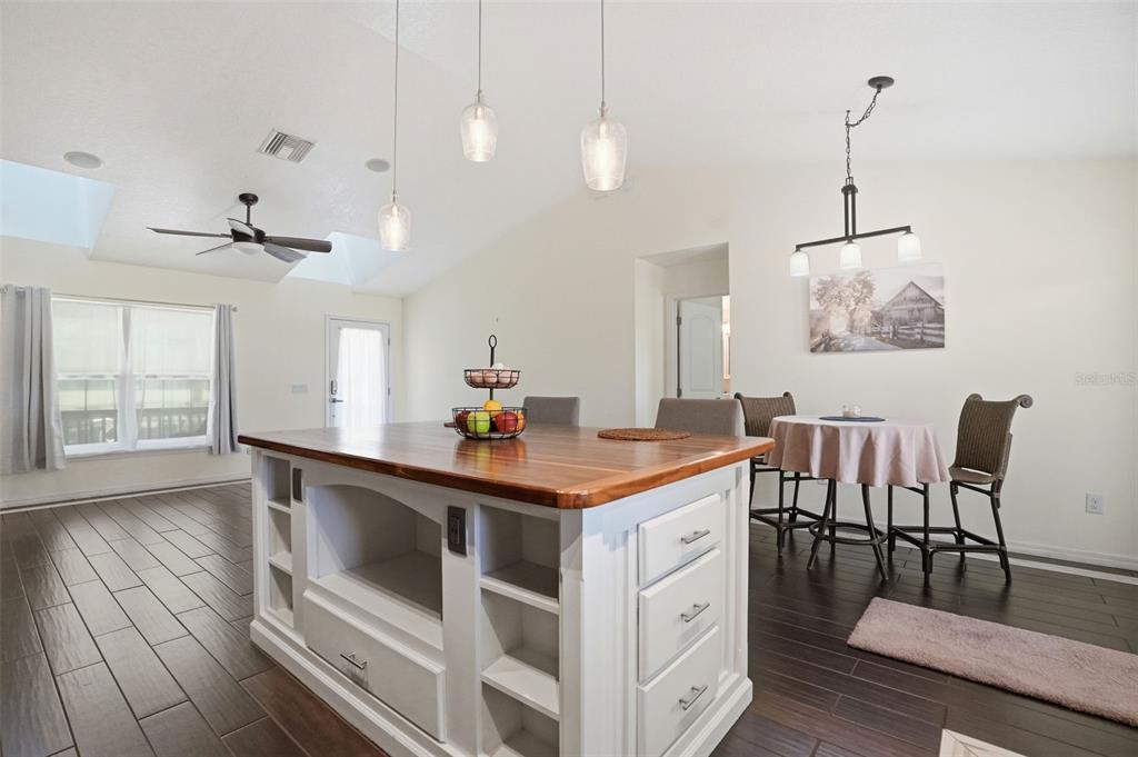 7037 County Road 625 Bushnell, FL 33513 - Photo 29 of 99 a kitchen with stainless steel appliances granite countertop a stove a sink a dining table and chairs with wooden floor