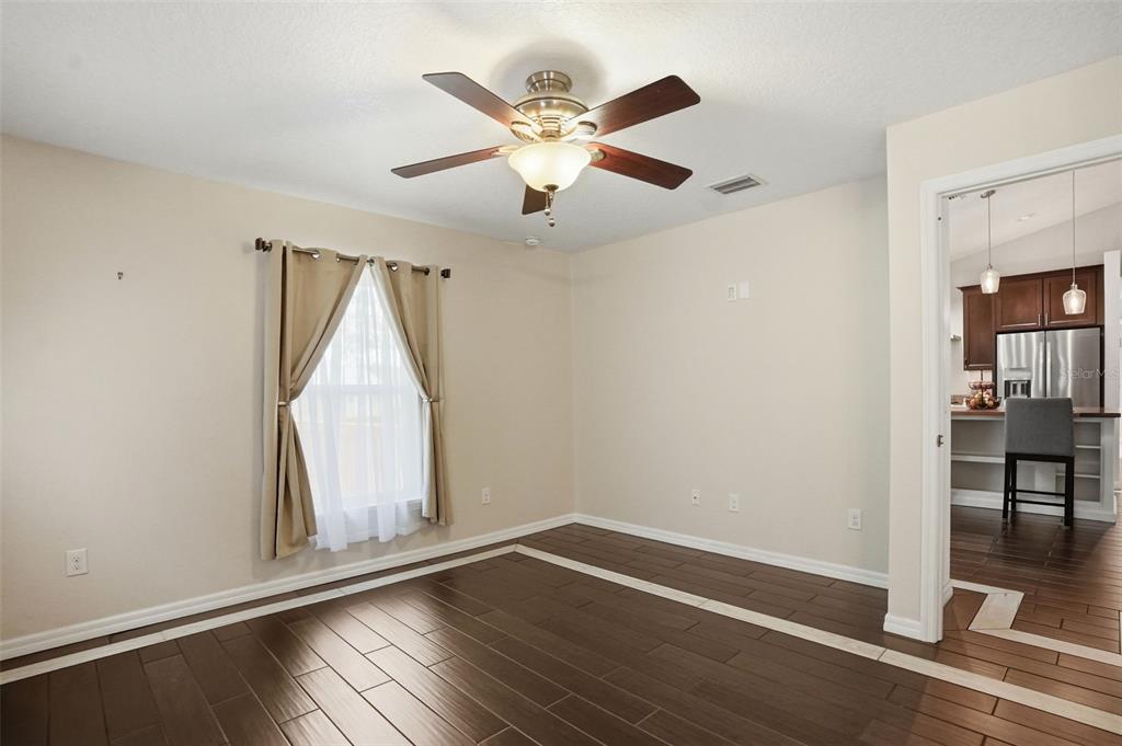 7037 County Road 625 Bushnell, FL 33513 - Photo 36 of 99 an empty room with wooden floor fan and windows