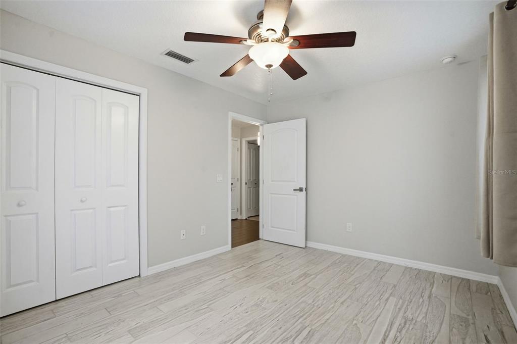7037 County Road 625 Bushnell, FL 33513 - Photo 50 of 99 an empty room with wooden floor chandelier fan and closet area